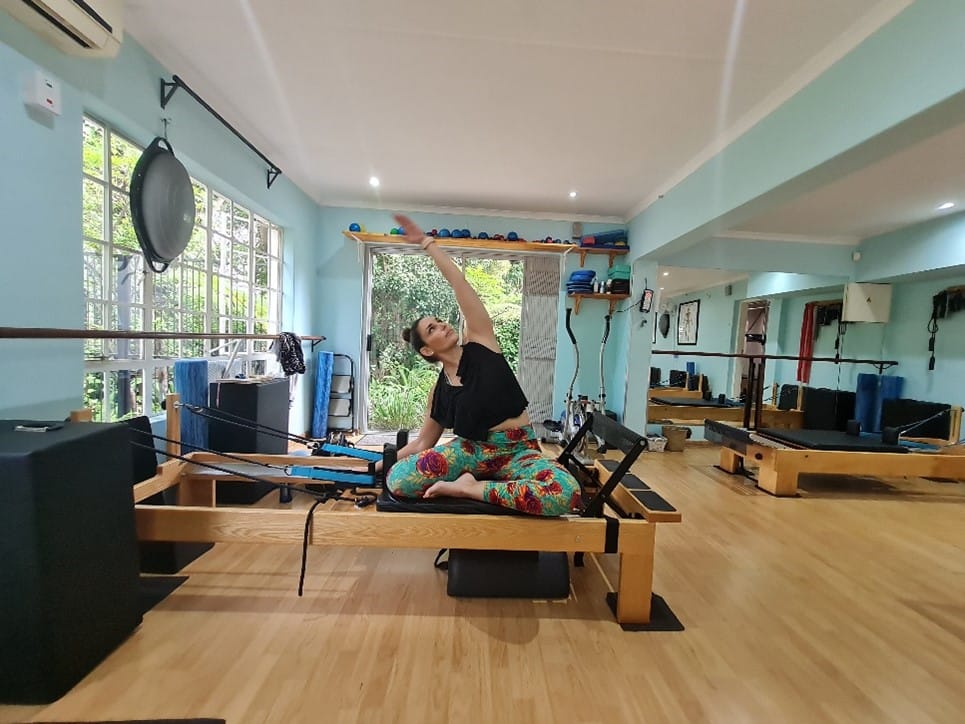 Pilates Teacher demonstrating pose Different Types of Pilates