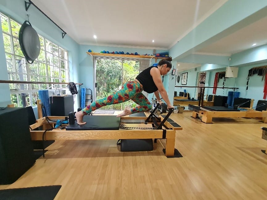 Pilates Teacher demonstrating pose Different Types of Pilates